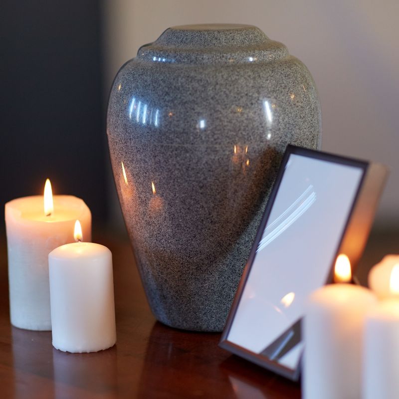 a gray urn surrounded by candles